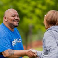 Two players smile and shake hands after a game